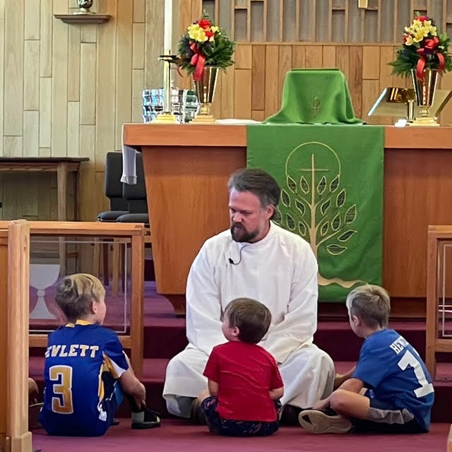 Presider preaching to children